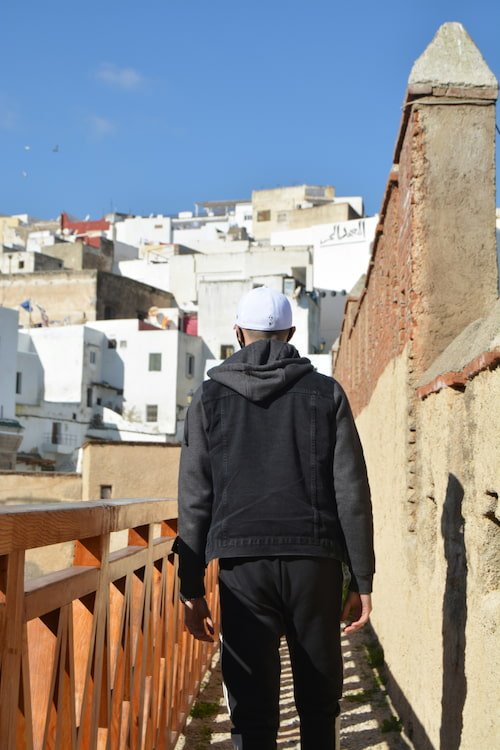 A man walking down a narrow street in Tetouan