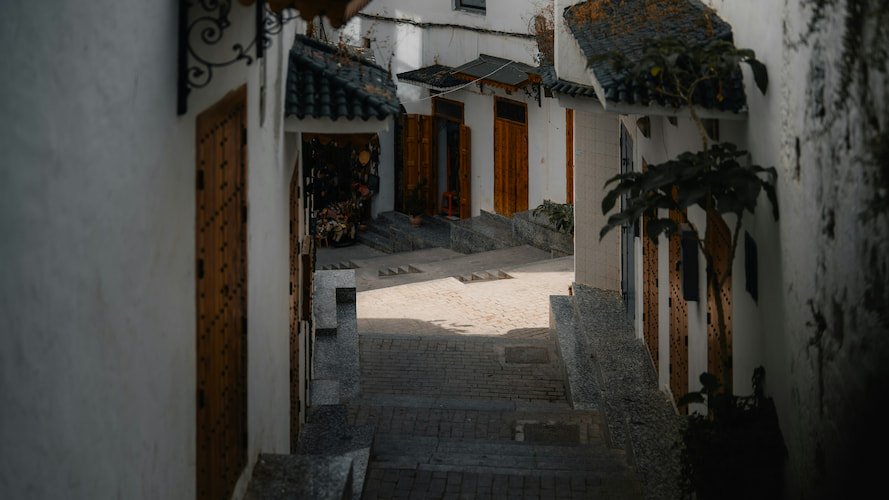 A man walking down a narrow street in Tetouan
